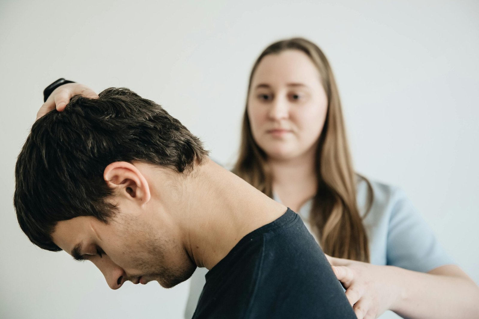 A physiotherapist guiding a patient through gentle neck exercises to relieve cervical spondylosis pain and improve mobility